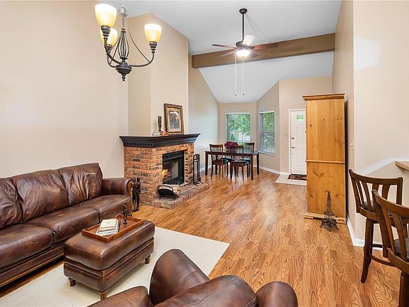 Living room & dining room have vaulted ceiling with skylight, updated lighting & open to kitchen with breakfast bar.