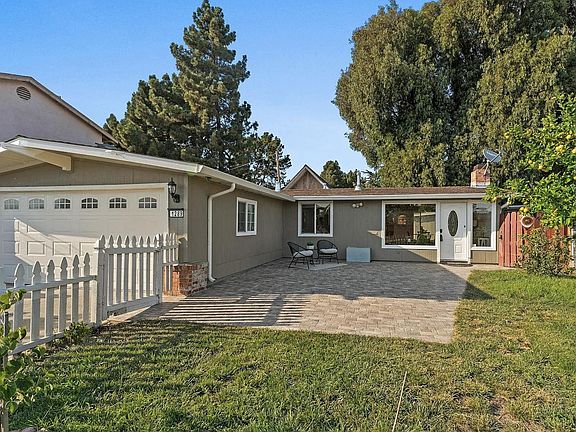 Greeted by a charming picket fence and fully enclosed paved front yard with a mature citrus tree, you will instantly feel the charm of this ranch style home.