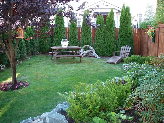 Front Yard w/Pyrmidalis border & inviting rockery for entry