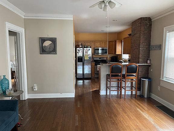 Open, modern kitchen, with bar seating, flows into dining area.