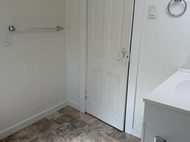 View of bathroom with door closed to show towel bar and robe hook