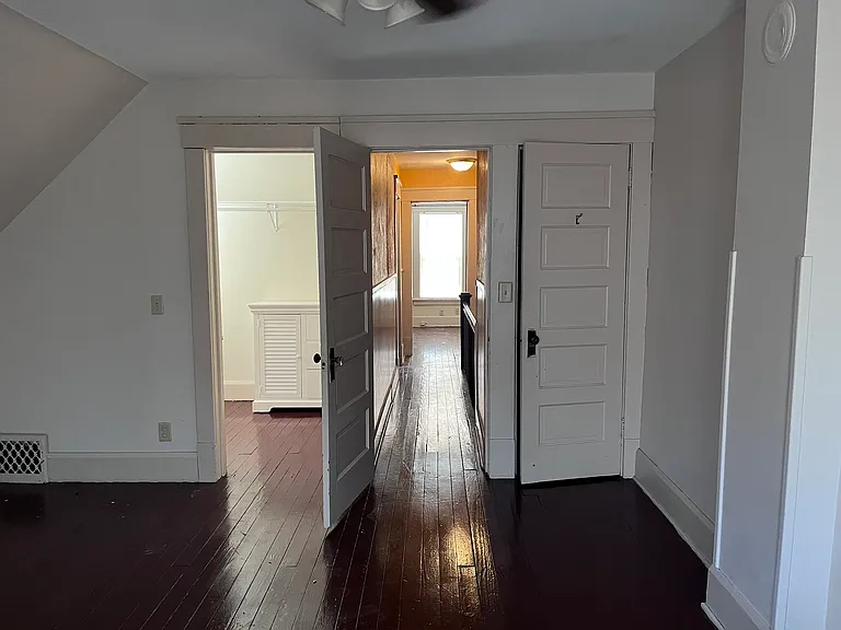 Looking at the entrance to the master bedroom from the Hall seeing all the way into the second bedroom. On the right is a small closet. On the left is the walk in closet with a dresser drawer storage.