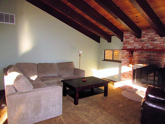 living room with new carpets, fire burning fireplace and bea