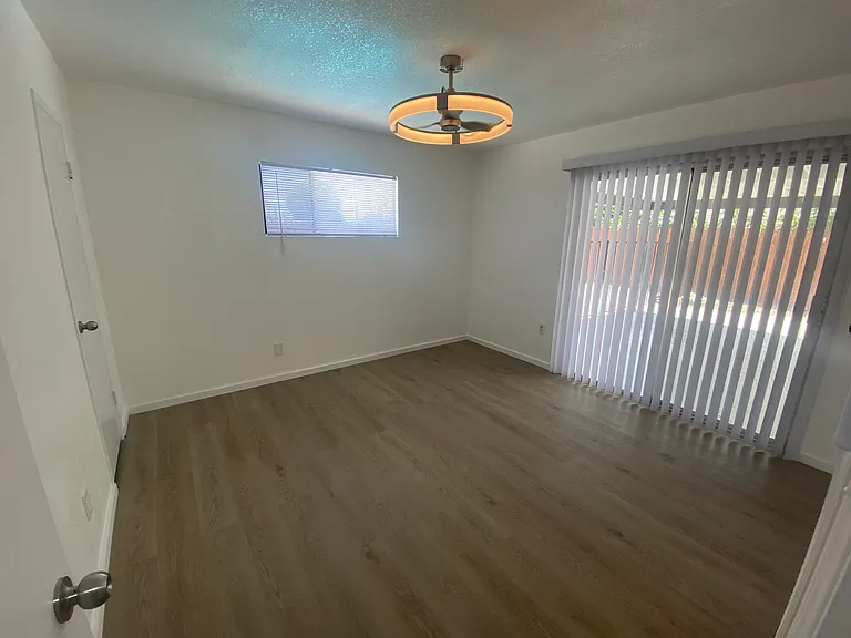 Master bedroom with sliding glass door leading to patio and pool area.
