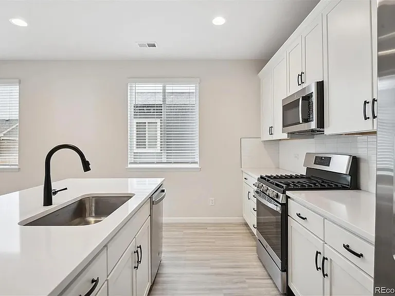 Side View of Kitchen, with SS appliances and Upgraded Quartz Countertop and Upgraded White Cabinets and Hardware