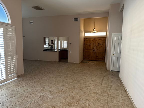 View of Double Door Entry and Kitchen with Service Opening to Formal Dining Room from Formal Living Room