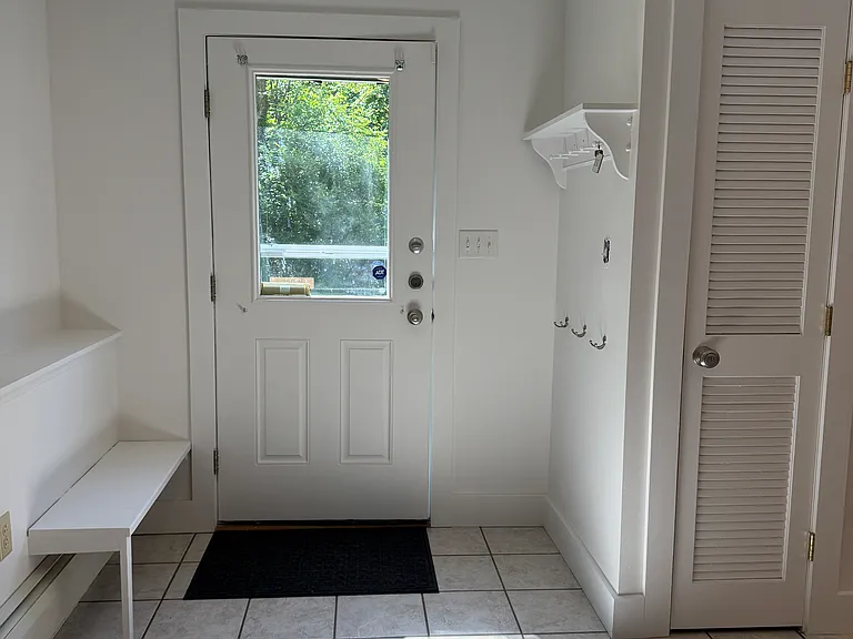 Entrance to apartment. Bench, coat hooks and shelf for easy organization. Pantry/Storage closet.