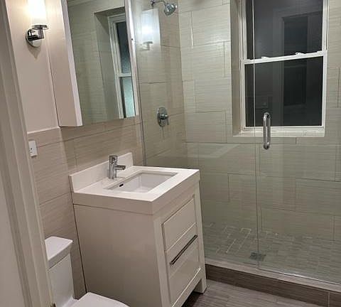 Toto Toilet. Medeli bath cabinet and mirror with Quartz top and drawer storage. Hangrohe shower fittings. Italian Porcelain flooring/shower walls.