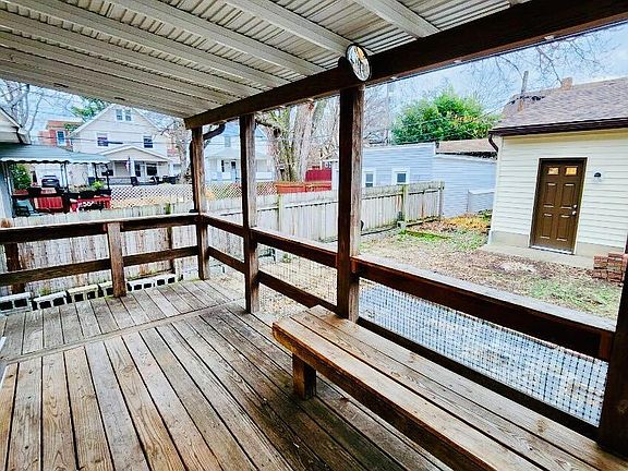 Covered, wooden porch with access to backyard