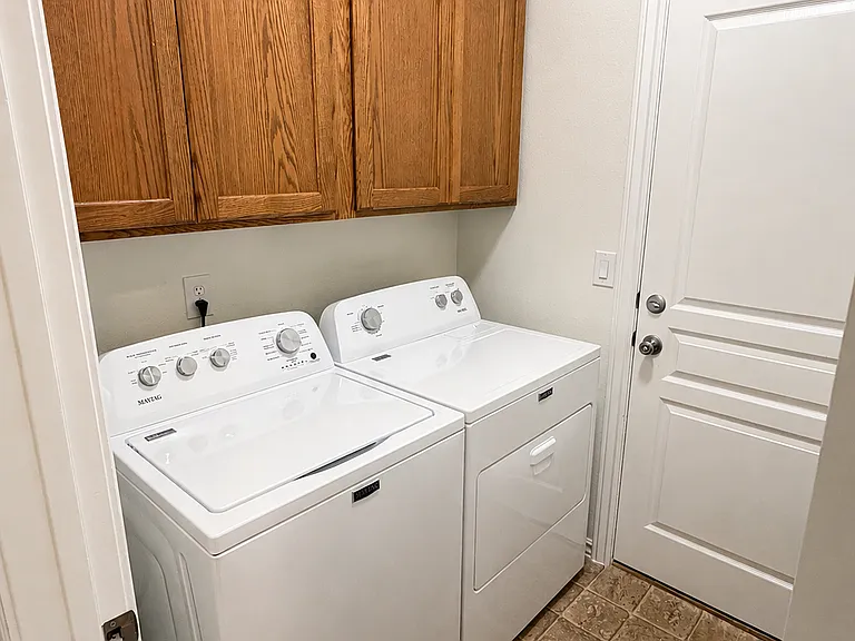 Laundry room with new washer and dryer and door to the garage