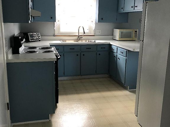 Kitchen with appliances, including microwave and toaster oven.