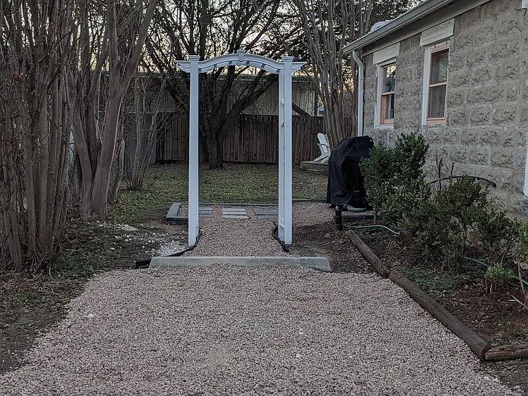 East driveway with arbor leading to the backyard. Two cars will fit in this driveway.