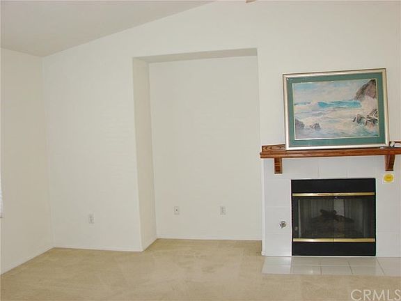 ONE SECTION OF THE LIVING ROOM WITH MEDIA ALCOVE AND ADJOINING GAS LOG FIREPLACE.