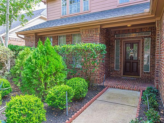 Lush landscaping escorts you to the bricked front porch--giving you a hint of the treasures you will find inside. Note, the roof was replaced in 2012.