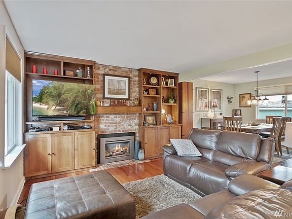 The formal living room is spacious and inviting and features a lovely gas fireplace with built-in shelving and open sight lines to the dining room.