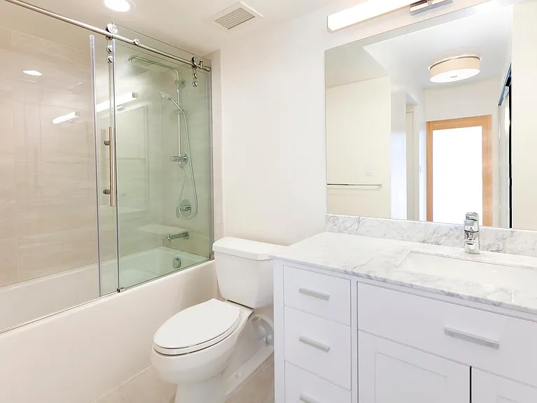 A chic and stylish full bathroom, with a sliding glass divider and a fully functioning bath tub. This is a combination of wide range, and heavy duty bathroom parts.