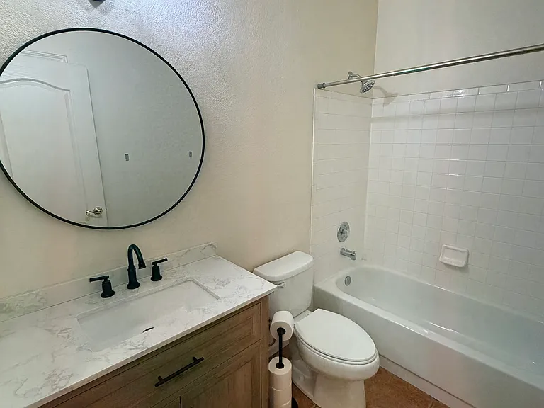 guest bathroom featuring a single vanity, bathtub/shower and linen closet