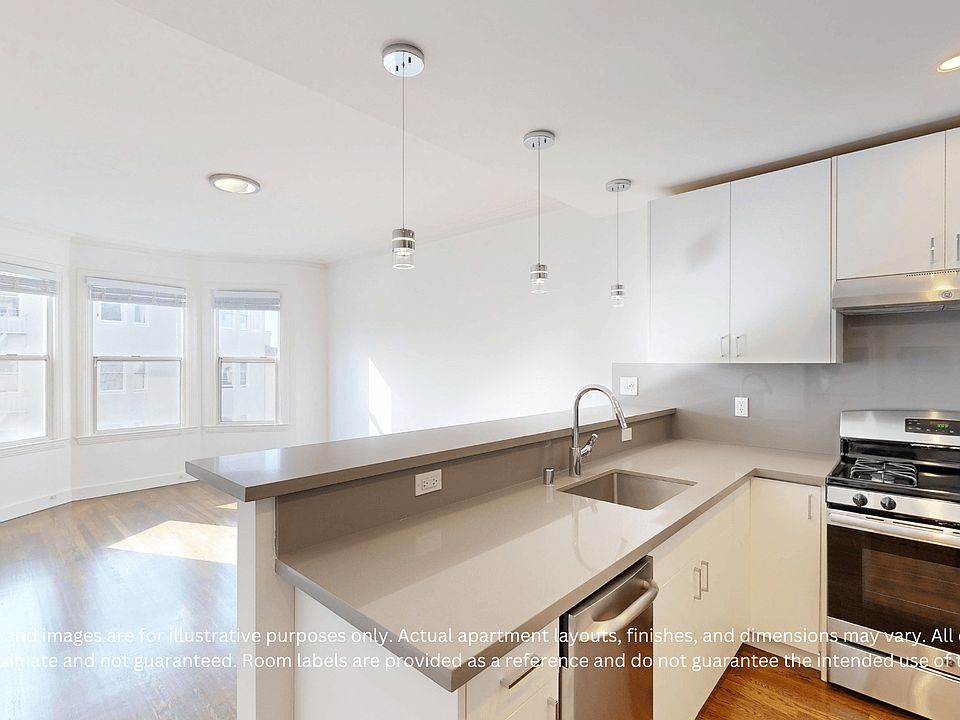 Bright modern kitchen featuring a sleek countertop, stainless steel appliances, and large windows for ample natural light.