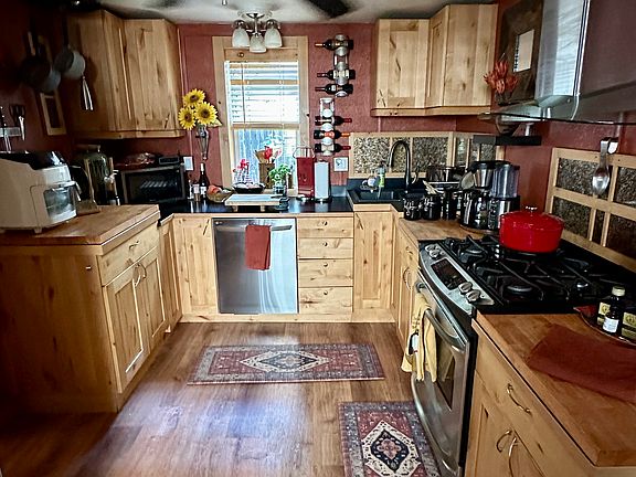 Kitchen with gas range and countertop microwave.