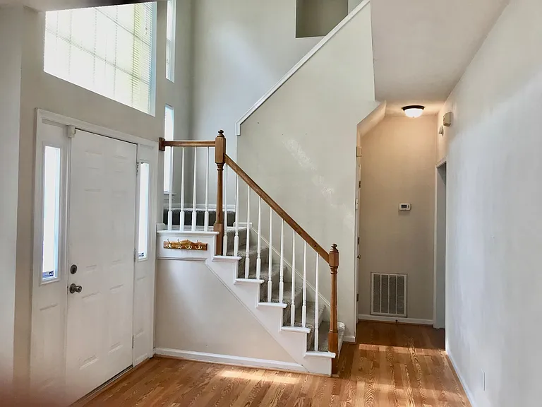 Foyer with hallway to the kitchen and den. Cathedral ceiling stairway to second floor.