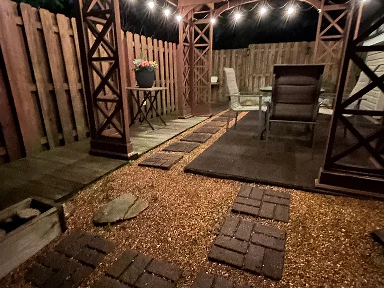 Moody back covered & fenced patio with lighting.