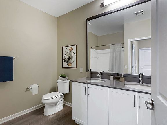 Renovated Package II bath with grey quartz countertops, white cabinetry, and hard surface flooring