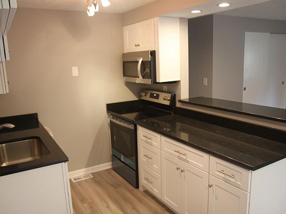 Open kitchen with bar top looks out into spacious living roo