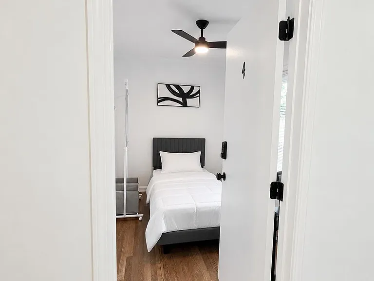 Private bedroom with a twin bed, ceiling fan, and wood-look flooring, plus space for essentials and easy access to daylight.
