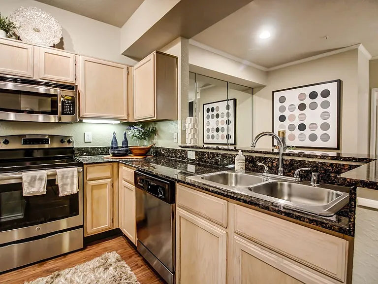 Stunning kitchen with hardwood style flooring, light colored cabinetry and stainless steel appliances