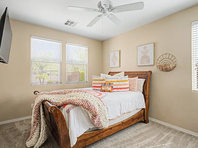 The first-floor bedroom overlooks the backyard and pool, offering a peaceful view. It is the only bedroom located downstairs, while all additional bedrooms are situated on the second floor.
