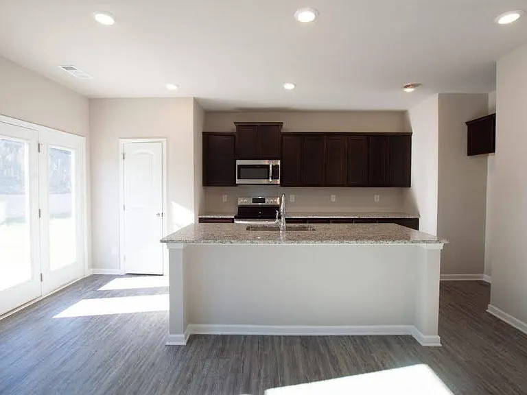 Kitchen with recessed lights and new Samsung fridge.