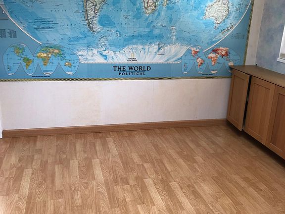 Laminate floor and world map on one wall in kitchen