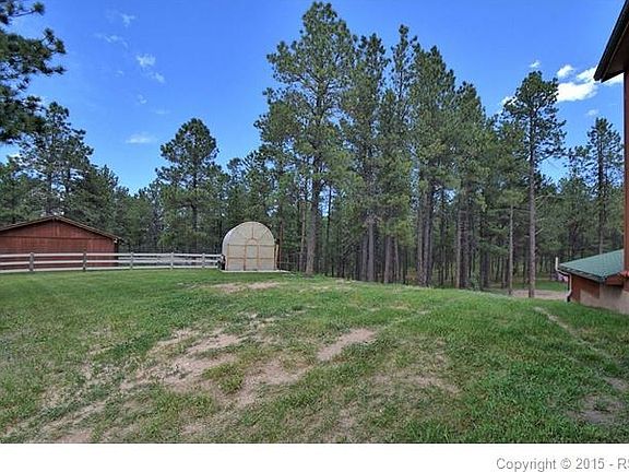 The rear yard is fenced for pets and has a greenhouse.