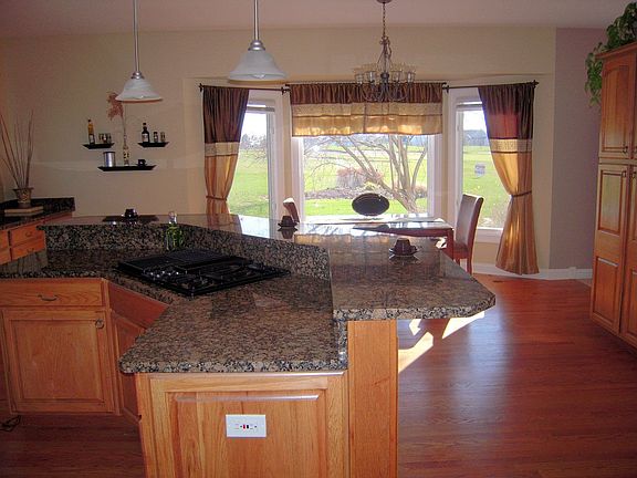 Granite breakfast bar, wood floors, cooktop, easy cooking triangle. Sliding dr