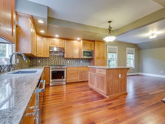 New natural cherry cabinets, slab granite counters, stainless appliances, cherry floor. Family room in distance