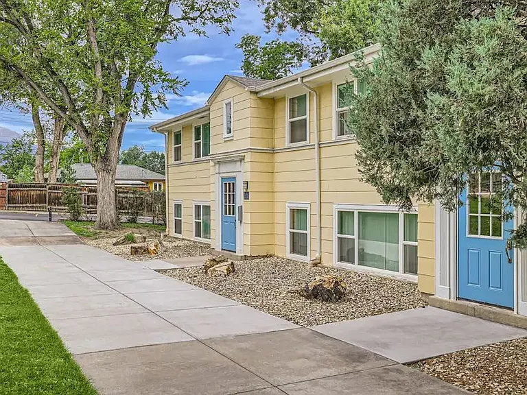 Exterior yellow building with blue doors and long walkway