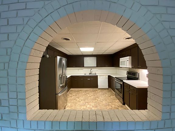 Opening in the brick wall between the living room and kitchen