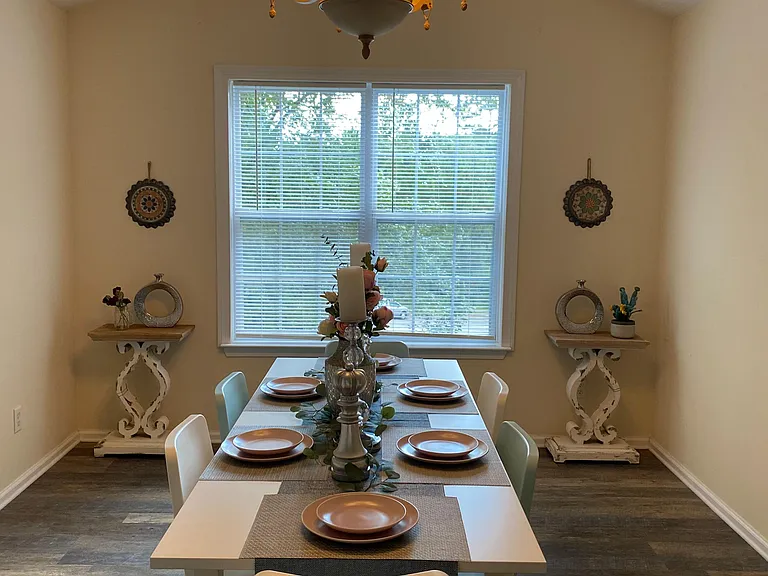 Dedicated dining area with a chandelier centerpiece and a large window, offering comfortable seating for shared meals.