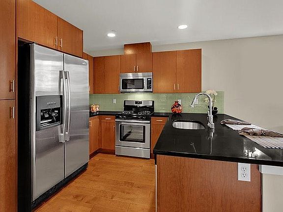 Kitchen with solid surface counters, solid cherry cabinets and high end appliances with a gas cooktop.