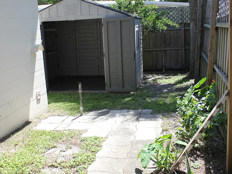 back of the house leading to side yard with large shed for bikes