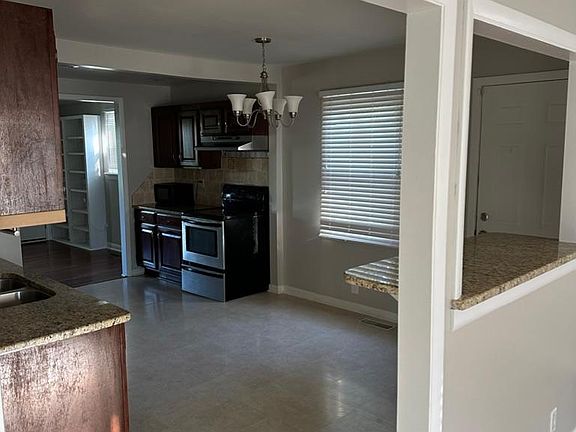 View of kitchen from living room in front of house