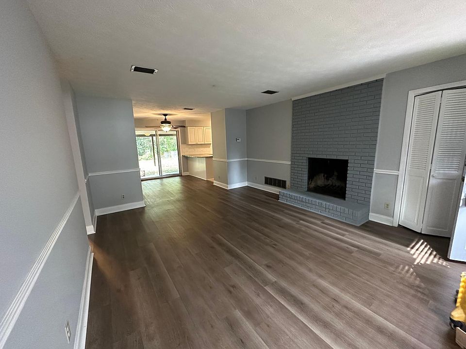 Open floor plan with living room, dining area and kitchen extended counter centered around the cozy brick fireplace and new floors.