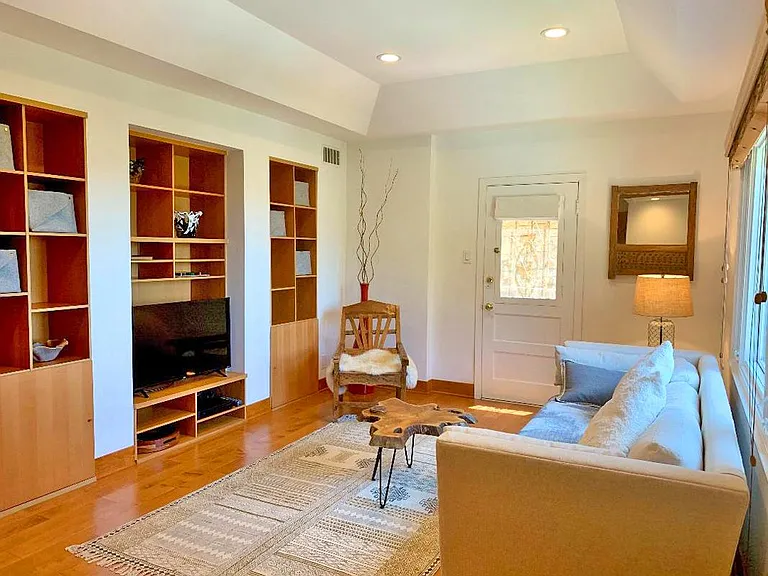 Living room, 8 foot couch, in set book shelves, small 'door window' that opens, and tray ceiling.