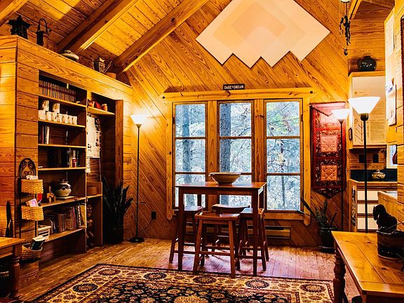 View of living room & work/game table. Glorious woods out windows