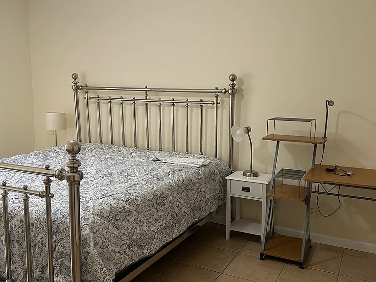 master bedroom with king bed, dresser and two night stands and desk