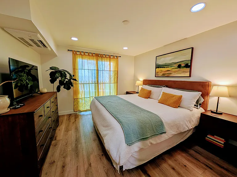 Primary bedroom - King bed, smart TV, walk-in closet, ensuite bathroom, access to private patio, open space views.