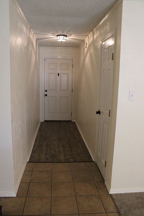 Looking at front door from living room. Hall closet to the right