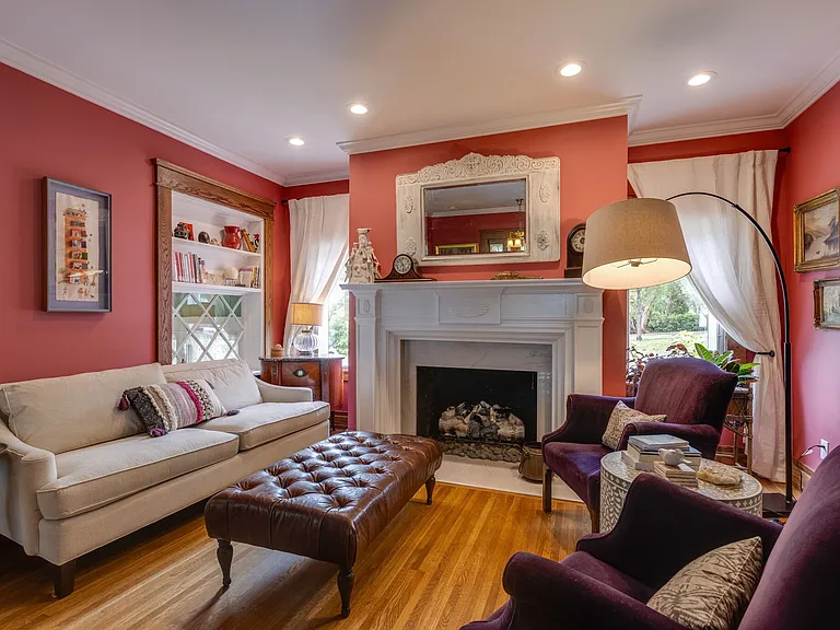 Formal living room with fireplace, built-ins and warm natural light.