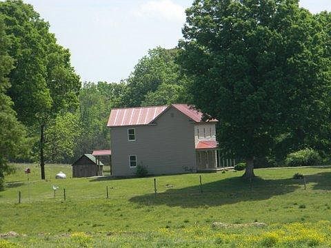 Left side of house with little garden shed and propane tank in distance