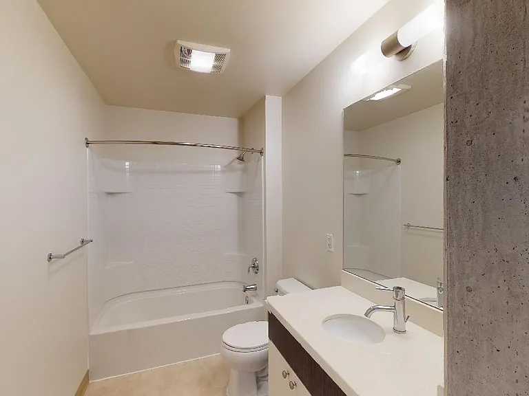 Apartment bathroom with wood-style flooring.